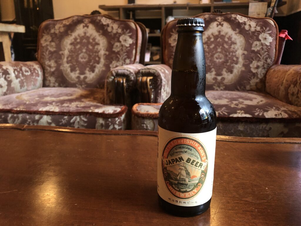 テーブルに置かれた復刻版ラベルの多摩の恵みというビールです
