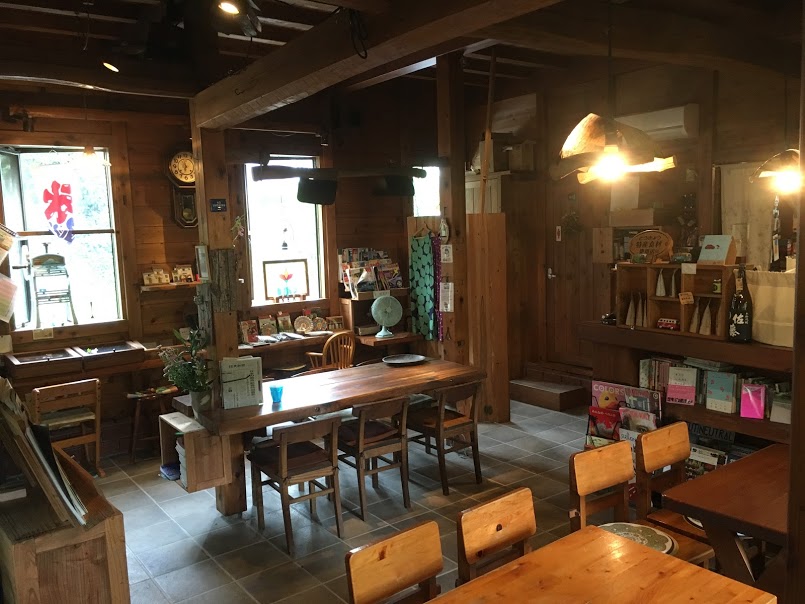 本棚とテーブル席があるカフェの店内です
